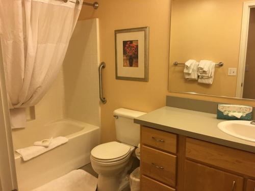 a bathroom with a toilet and a tub and a sink at Seaside Ocean Front Condo in Seaside