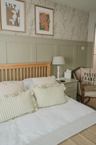 a bedroom with a white bed with pillows and a chair at The Beach House in West Wittering