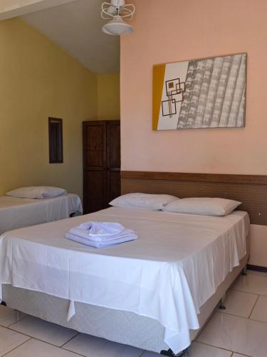 a bedroom with two beds with white sheets at Big Valley Hotel Fazenda in Serra Negra