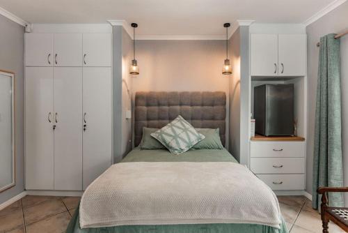 a bedroom with a large bed and a tv at Santa Stay in Stellenbosch