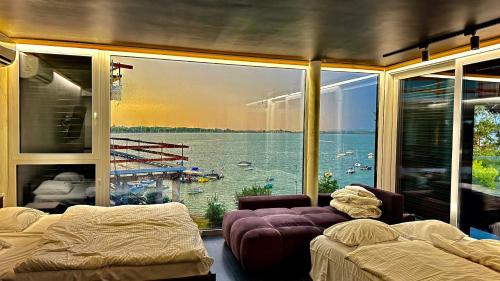 a bedroom with a large window with a view of the water at OW Mewa domki apartamenty nad jeziorem in Nysa