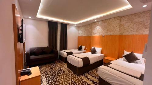 a hotel room with two beds and a couch at فندق إتقان المشاعر in Mecca