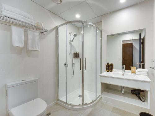 a bathroom with a shower and a toilet and a sink at Mercure Wellington Abel Tasman in Wellington