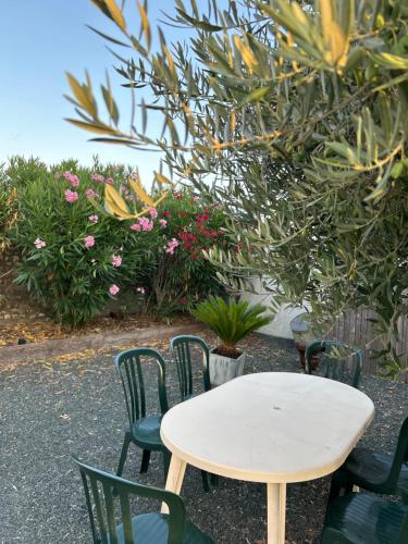 a white table and chairs with flowers and plants at L'Olivier in Charron