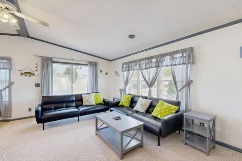 a living room with a black leather couch and a table at Assateague Point - Bay Breeze in Berlin
