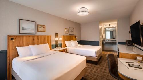 a hotel room with two beds and a desk at Ayres Lodge Alpine in Alpine