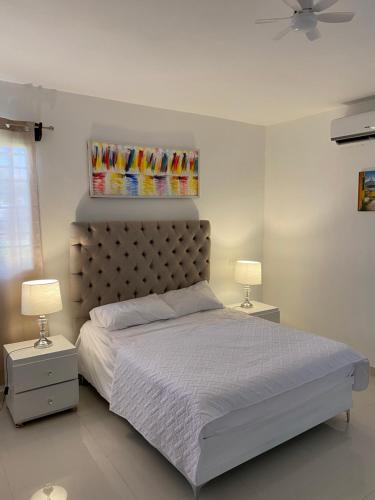 a bedroom with a large bed with two lamps at top apartments in Santo Domingo