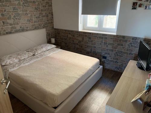a bedroom with a bed with a brick wall at Ribera villa alloggio 1 in Ribera