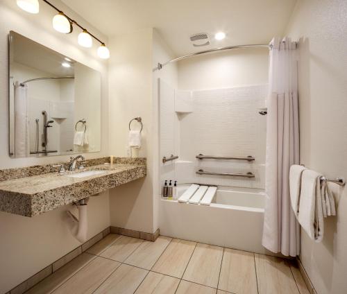 a bathroom with a tub and a sink and a shower at Ayres Lodge Alpine in Alpine