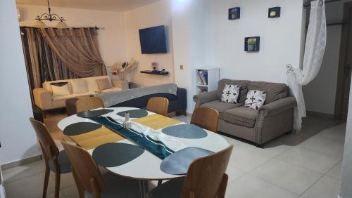 a living room with a table and a couch at Appart Bougainvillier in Libreville