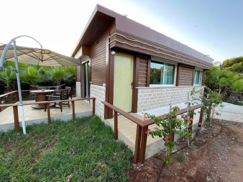 a small house with a table and an umbrella at palmeraie4 in Skhirat