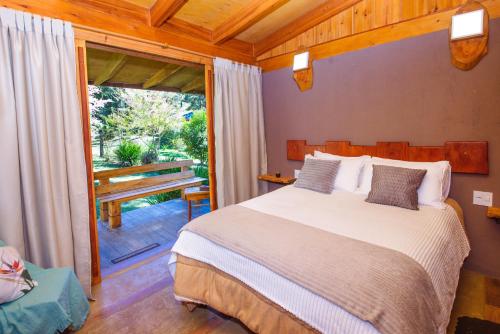 a bedroom with a bed and a sliding glass door at Espaço Gata Mourisca in Camanducaia