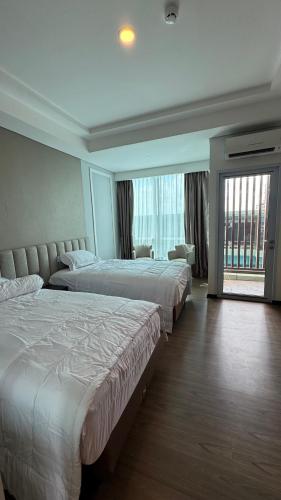 a hotel room with two beds and a large window at Panbil Residence Apartment - Studio 2 Bed in Bagam