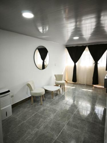 a room with chairs and a table and a mirror at Apartaestudio en Cali in Cali