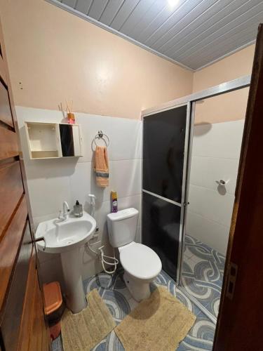 a bathroom with a toilet and a sink and a shower at Casapalmares in Parintins