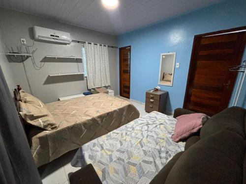 a room with two beds in a room with blue walls at Casapalmares in Parintins