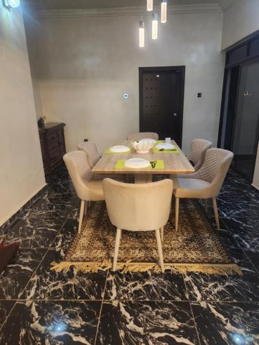 a dining room with a wooden table and chairs at Afiraiserviceapartment in Kaduna