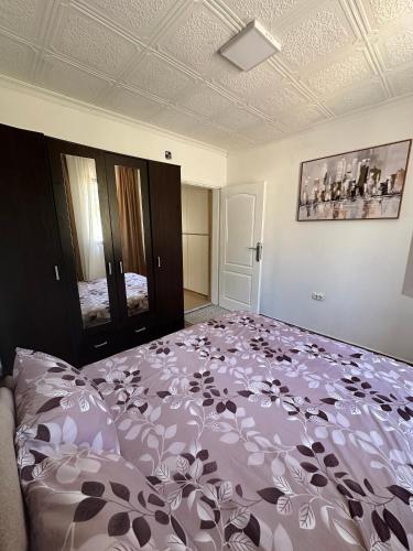a bedroom with a large bed with a purple blanket at Apartman Đurišić in Prijevor