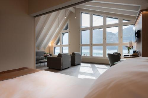 a bedroom with a bed and a large window at Hotel Safiro in Fluelen