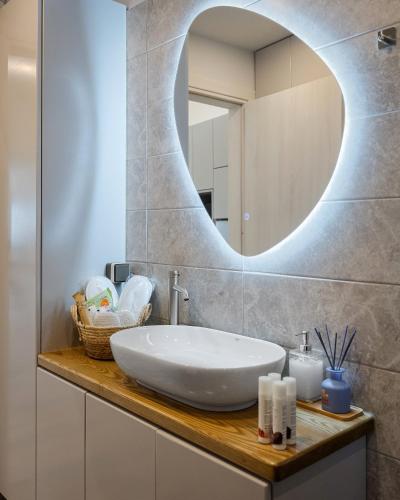 a bathroom with a white sink and a mirror at Limen Port View Studio in Tinos