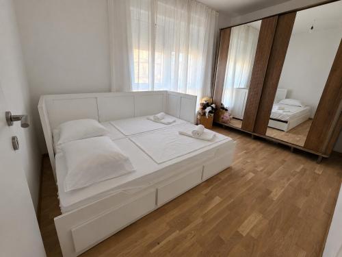 a white bed in a room with a mirror at Mare Ann in Ljubuški