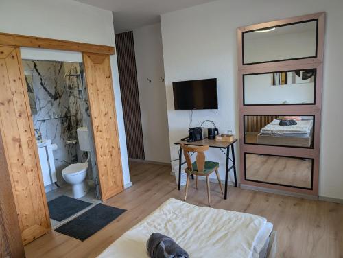 a room with a bed and a desk with a television at Herzogberghof in Kindberg