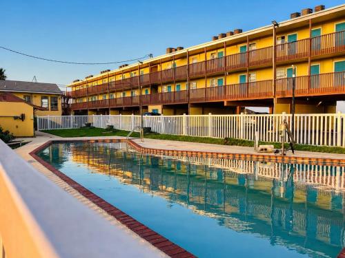a swimming pool in front of a building at ORO North Beach Inn in Corpus Christi