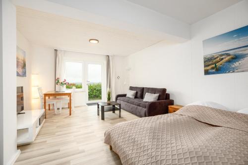 a bedroom with a bed and a couch and a desk at Fördeperle Laboe in Laboe