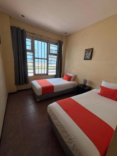 a hotel room with two beds and a window at Hotelito Fiesta Caribena in Coatzacoalcos