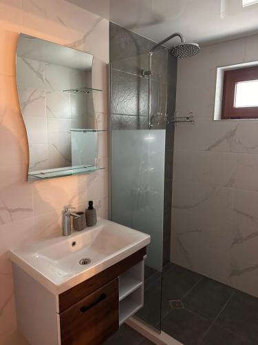 a bathroom with a sink and a glass shower at Къща за гости ХидроТера - Велинград in Velingrad