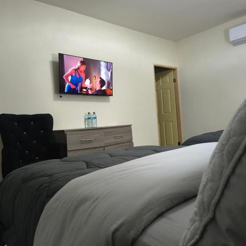 ein Schlafzimmer mit einem Bett und einem Fernseher an der Wand in der Unterkunft Mukí Galá in Creel