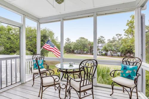 a screened porch with a table and chairs at Heh Edisto in Edisto Beach