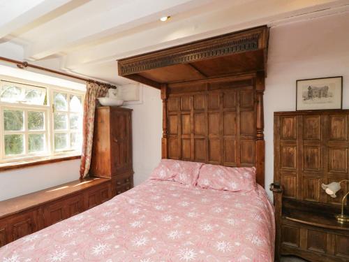 a bedroom with a bed and a wooden headboard at Ivy Cottage in Bath
