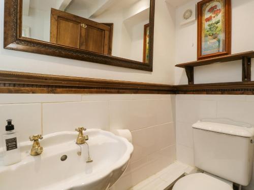 a bathroom with a toilet and a sink and a mirror at Ivy Cottage in Bath