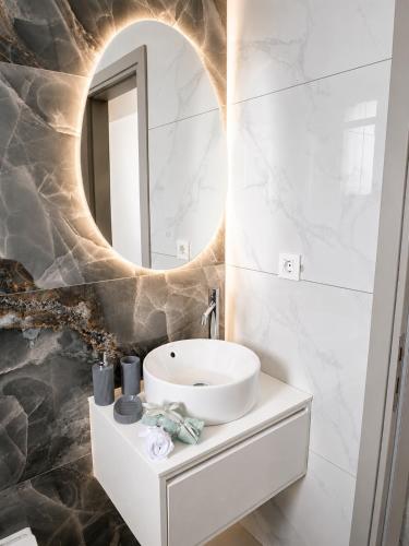 a bathroom with a sink and a mirror at Haraki Emerald in Haraki