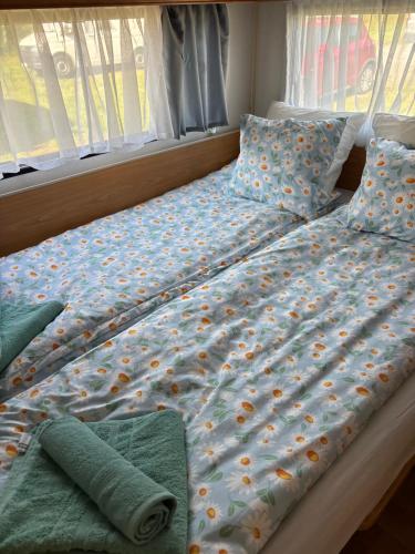 a bed with a comforter with flowers on it at Lille Ro in Giskemo