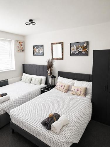 two beds in a room with white walls at Roclems Homes in Grays Thurrock