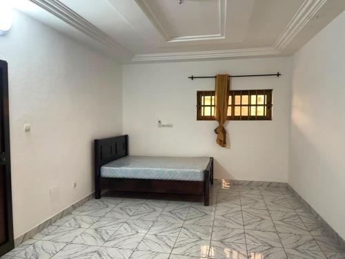 a room with a bed and a window in it at RESIDENCE Chez PETER in Alakopé
