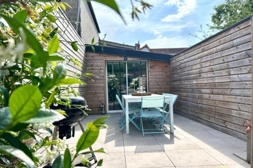 a patio with a table and chairs on it at Maison de charme 8p Jardin Baie de Somme in Abbeville