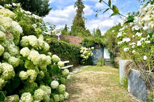 a garden with a bench and some bushes and flowers at Maison de charme 8p Jardin Baie de Somme in Abbeville