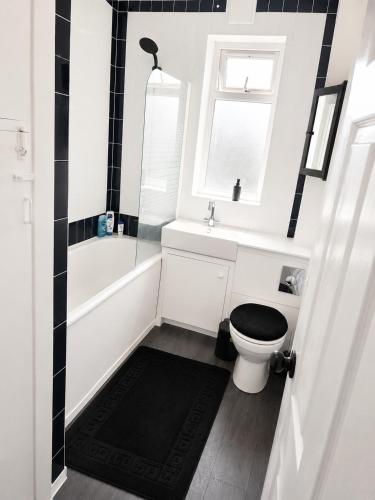 a bathroom with a toilet and a tub and a sink at Roclems Homes in Grays Thurrock