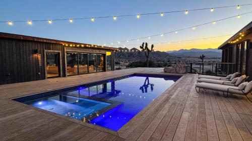 a house with a swimming pool on a deck at Iconic 7,000sf Glass Villa with 2 Pools on 350 Acres in Pioneertown