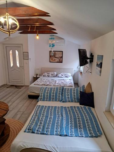 a room with two beds and a tv in it at Studio Apartments KIM - Dilberovic in Mostar