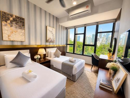 a hotel room with two beds and a desk at Ceylonz Suites KLCC By KL Tower in Kuala Lumpur