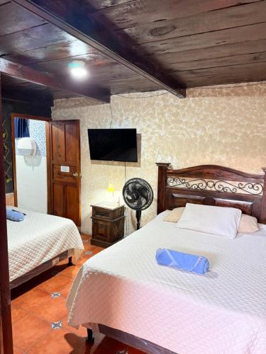 a bedroom with two beds and a flat screen tv at Cristales de Antigua Hotel Cristal in Antigua Guatemala