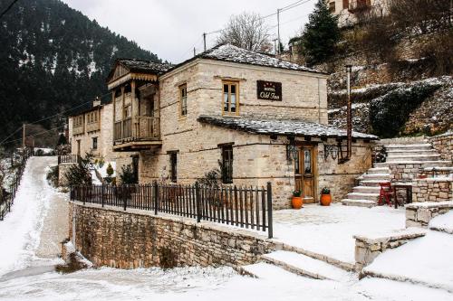 an old stone building with snow on the ground at Old Inn in Karpenision