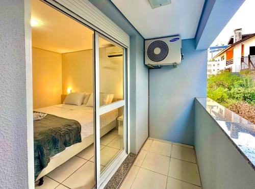 a small bedroom with a bed and a window at Executive - 106 No Garage in Caxias do Sul