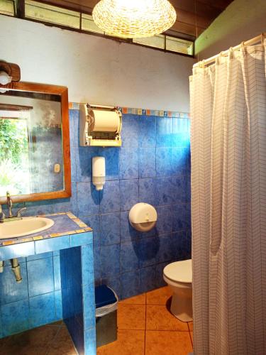 a bathroom with a sink and a toilet and a mirror at Escape Caribeño in Puerto Viejo