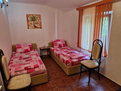 ein Schlafzimmer mit zwei Betten, einem Stuhl und einem Fenster in der Unterkunft Carmen in Bijela
