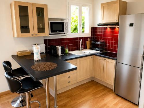 a kitchen with a stainless steel refrigerator and a sink at Grand T2 calme avec parking privé à Toulouse in Toulouse